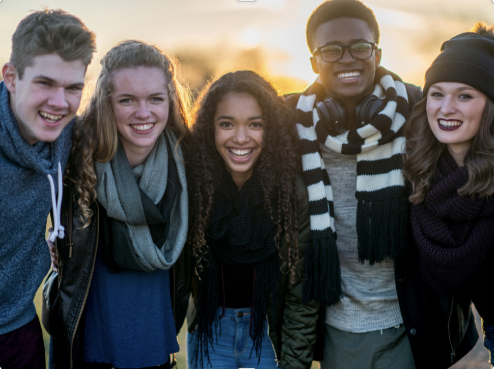 5 young adults or youth, smiling at the camera.